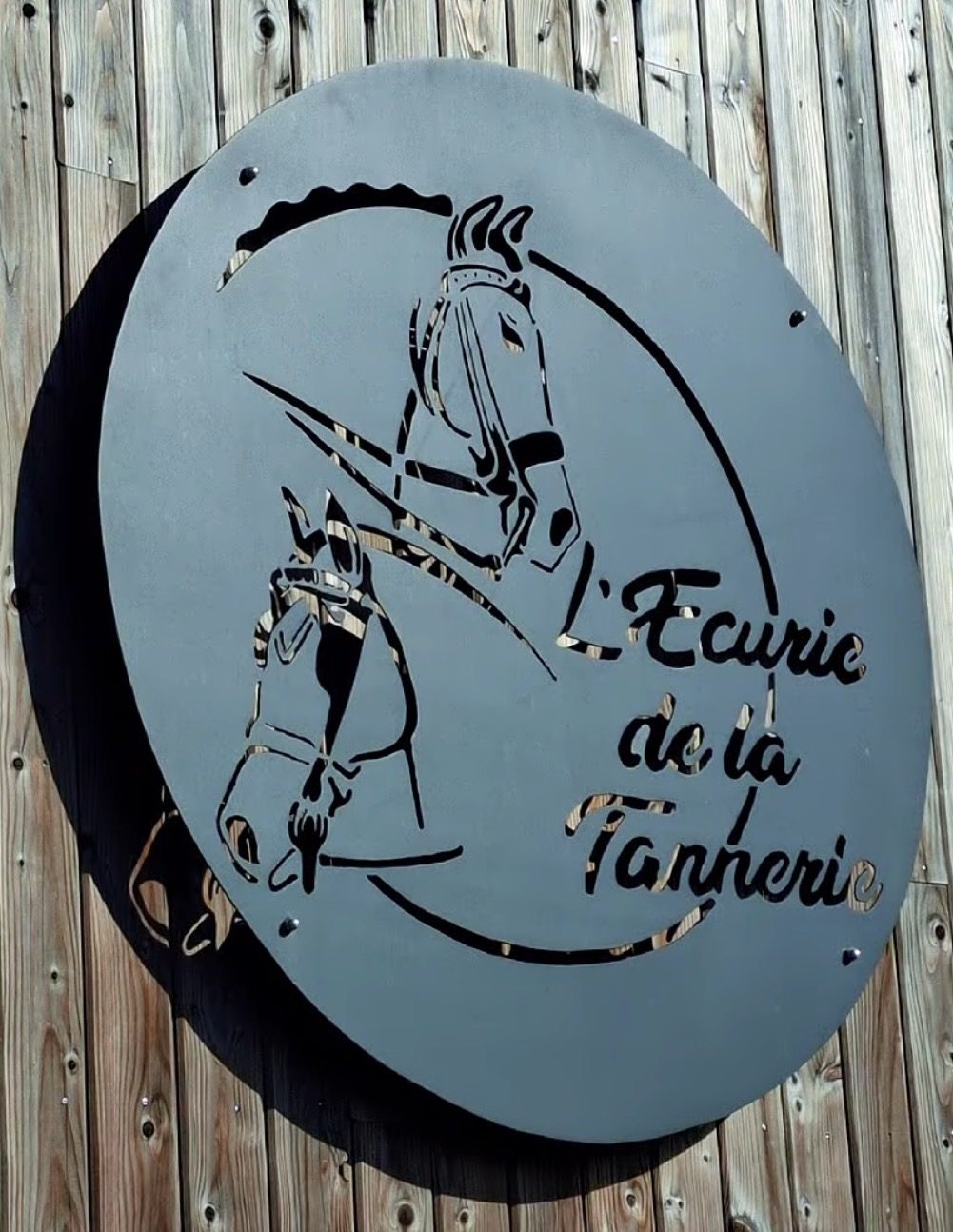 L'enseigne en métal découpé de l'Écurie de la Tannerie, à l'entrée du site